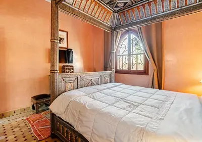 a bedroom with a large bed and a window at Private 3 Bedroom Riad Exclusive Use for Families and Friends in Marrakech