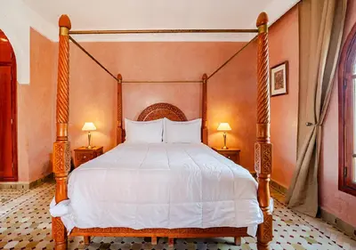 a bedroom with a canopy bed with white sheets at Private 3 Bedroom Riad Exclusive Use for Families and Friends in Marrakech