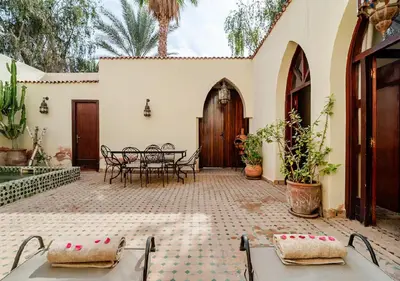 a courtyard of a house with a table and chairs at Private 3 Bedroom Riad Exclusive Use for Families and Friends in Marrakech