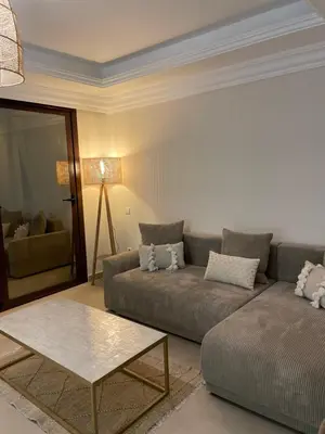 a living room with a couch and a table at Sublime Appartement JACCUZi privé piscine in Marrakech
