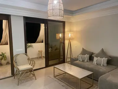 a living room with a couch and a table at Sublime Appartement JACCUZi privé piscine in Marrakech