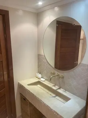 a bathroom with a sink with a large mirror at Sublime Appartement JACCUZi privé piscine in Marrakech