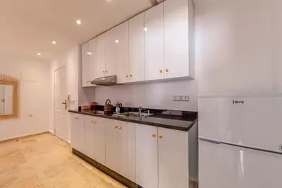 a kitchen with white cabinets and a refrigerator at Appartement moderne trés securisé a gueliz au centre ville in Marrakech