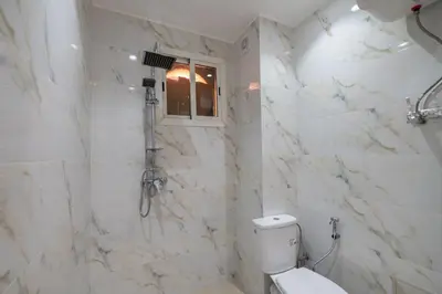 a white bathroom with a toilet and a shower at Appartement moderne trés securisé a gueliz au centre ville in Marrakech