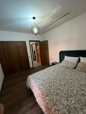 a bedroom with a large bed and a light at Appartement moderne 5 min au centre de ville proche du gueliz in Marrakech