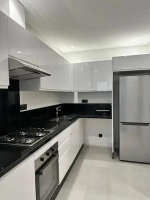 a kitchen with white cabinets and a stainless steel refrigerator at Marrakech Mood in Marrakech