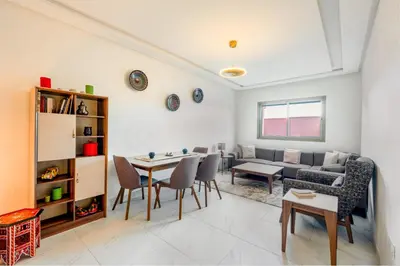 a living room with a couch and a table at Sunny Luxe 2BR Heaven Apt Wi-Fi, Balcony & Pool in Marrakech