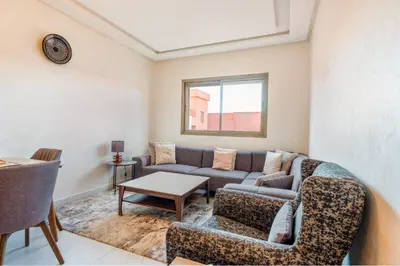 a living room with a couch and a table at Sunny Luxe 2BR Heaven Apt Wi-Fi, Balcony & Pool in Marrakech