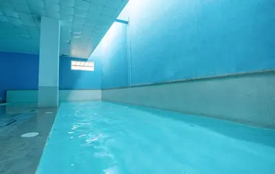 a swimming pool with blue water in a building at Modern Hivernage Appt New 2-BR w Pool & Terrace in Marrakech
