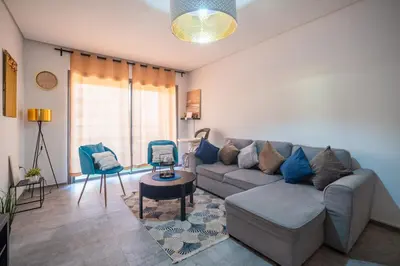 a living room with a couch and a chair at Modern Hivernage Appt New 2-BR w Pool & Terrace in Marrakech