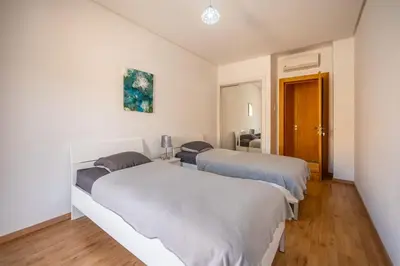 a bedroom with two beds and a room with a couch at Modern Hivernage Appt New 2-BR w Pool & Terrace in Marrakech