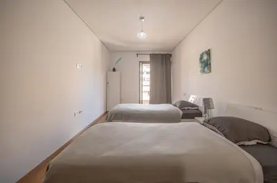 a bedroom with two beds and a refrigerator at Modern Hivernage Appt New 2-BR w Pool & Terrace in Marrakech