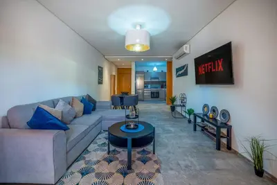 a living room with a couch and a table at Modern Hivernage Appt New 2-BR w Pool & Terrace in Marrakech