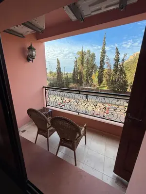 a balcony with two chairs and a large window at Kech in Marrakech