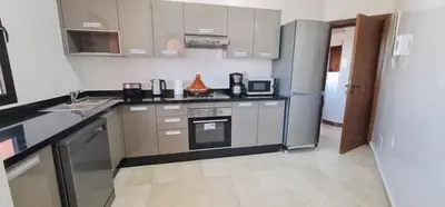 a kitchen with a stove and a refrigerator at Elegant Apartment in Marrakech Premium Village with Five Pools & Free Parking in Marrakech