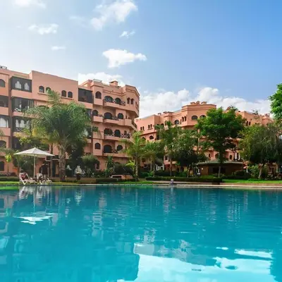 a large pool of blue water in front of a building at Elegant Apartment in Marrakech Premium Village with Five Pools & Free Parking in Marrakech