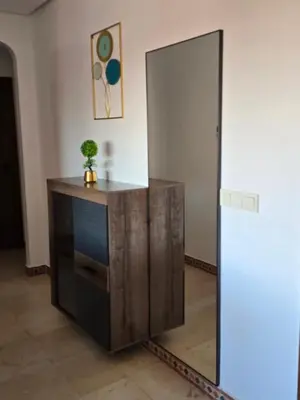 a wooden cabinet in a room with a mirror at Elegant Apartment in Marrakech Premium Village with Five Pools & Free Parking in Marrakech