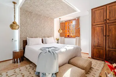 a bedroom with a large white bed and a couch at Riad Chelsie 103 Rooftop & SPA in Marrakech