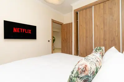 a bedroom with a bed and a tv on the wall at Luxury Apartment Hivernage 5 minutes from Jemaa El Fna in Marrakech
