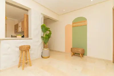 a living room with two stools and a green door at Luxury Apartment Hivernage 5 minutes from Jemaa El Fna in Marrakech