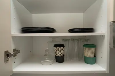 a white shelf with plates and dishes on it at Studio au cœur de Guéliz à 5 min de Jemaa el-Fna in Marrakech