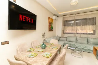 a living room with a table and a tv at Studio Hivernage 2 munit a la gare in Marrakech