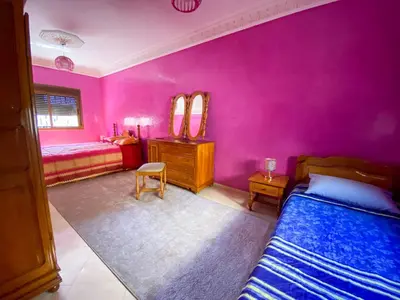 a bedroom with pink walls and a bed and a desk at Nice Apartment in Marrakesh in Marrakech
