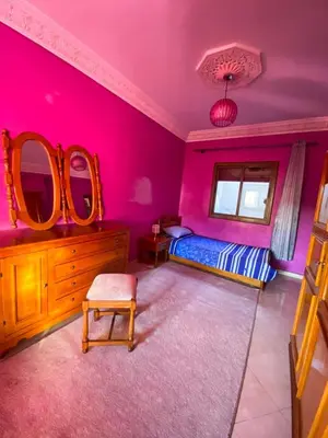 a bedroom with pink walls and a bed and mirrors at Nice Apartment in Marrakesh in Marrakech