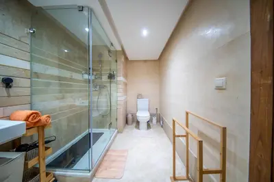 a bathroom with a glass shower and a toilet at Prestigious Duplex in the Center of Guéliz in Marrakech