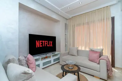 a living room with a couch and a television at Prestigious Duplex in the Center of Guéliz in Marrakech