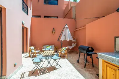 a patio with a table and chairs and an umbrella at Prestigious Duplex in the Center of Guéliz in Marrakech