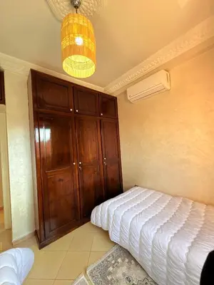 a bedroom with a bed and a large wooden cabinet at A haven of light & sweetness in Marrakech