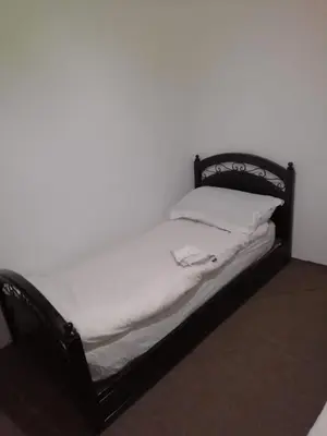 a bed with a black frame and a white pillow at Dar Essalam in Marrakech