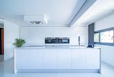 a white kitchen with white cabinets and a sink at Appartement luxe hivernage in Marrakech