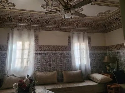 a living room with a ceiling fan and a couch at Dar Damana in Marrakech