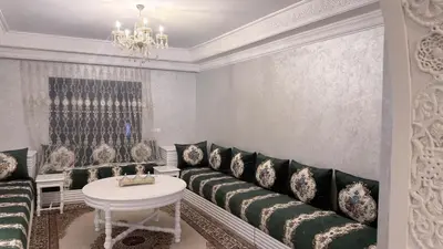 a living room with black and white furniture and a chandelier at 3 bedrooms 2 balconies kitchen, salon 2 bathrooms in Marrakech