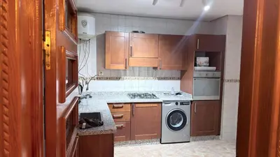 a kitchen with wooden cabinets and a washing machine at 3 bedrooms 2 balconies kitchen, salon 2 bathrooms in Marrakech