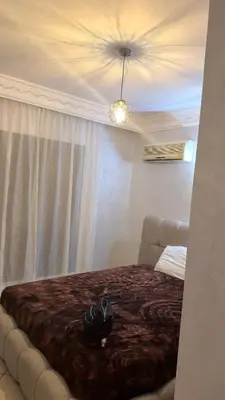 a bedroom with a large bed with a brown blanket at 3 bedrooms 2 balconies kitchen, salon 2 bathrooms in Marrakech