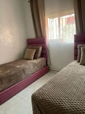 a bedroom with two beds and a window at Appartement confortable près de l'aéroport in Marrakech