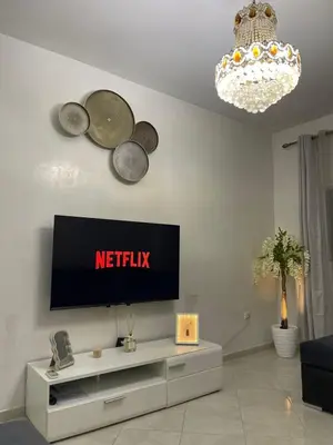 a living room with a flat screen tv on a wall at Appartement confortable près de l'aéroport in Marrakech