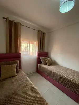 a bedroom with two beds and a window at Appartement confortable près de l'aéroport in Marrakech