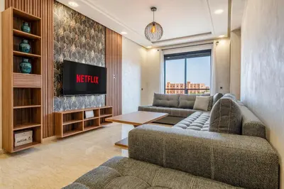 a living room with two couches and a tv at Stylish Apartment with Balcony view & Free Parking in Marrakech
