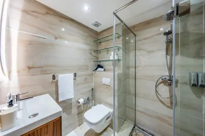 a bathroom with a toilet and a glass shower at Stylish Apartment with Balcony view & Free Parking in Marrakech