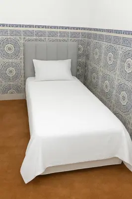 a white bed in a room with a wall at Dar Saada Bab Doukkala in Marrakech