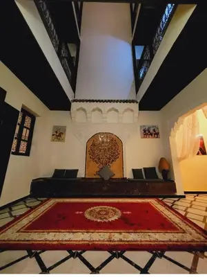 a living room with a red rug on the floor at Riad Privatif 250m2 près Médina-palais Royal in Marrakech