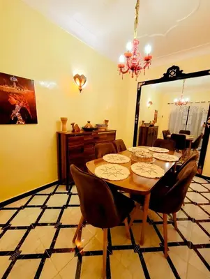 a dining room with a table and chairs and a mirror at Riad Privatif 250m2 près Médina-palais Royal in Marrakech