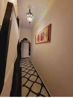 a hallway with a light and a painting on the wall at Riad Privatif 250m2 près Médina-palais Royal in Marrakech