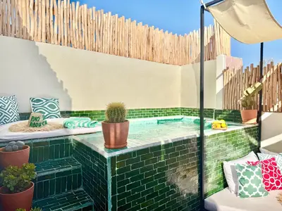 a patio with a pool with cacti and plants at Riad des bibouches pool breakfast private in Marrakech