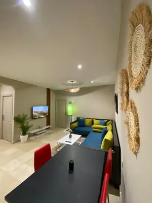 a living room with a table and a couch at Red city charm - city center apartment in Marrakech