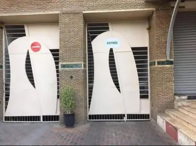 a building with two white doors with the word penguins at Nice apartment in Marrakech center in Marrakech